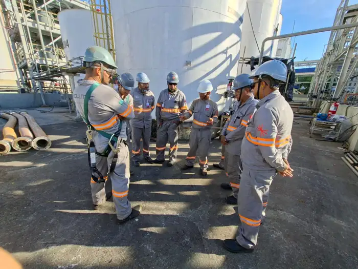 Equipe técnica da Solutec AM reunida em campo junto a tanques industriais — Manaus